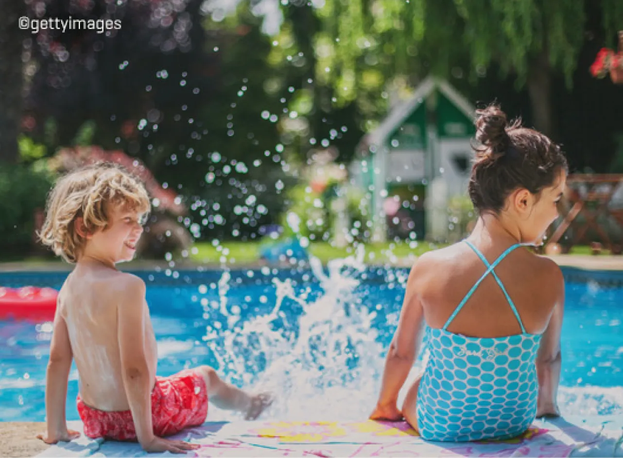 Deux enfants avec des pieds éclaboussant dans une piscine